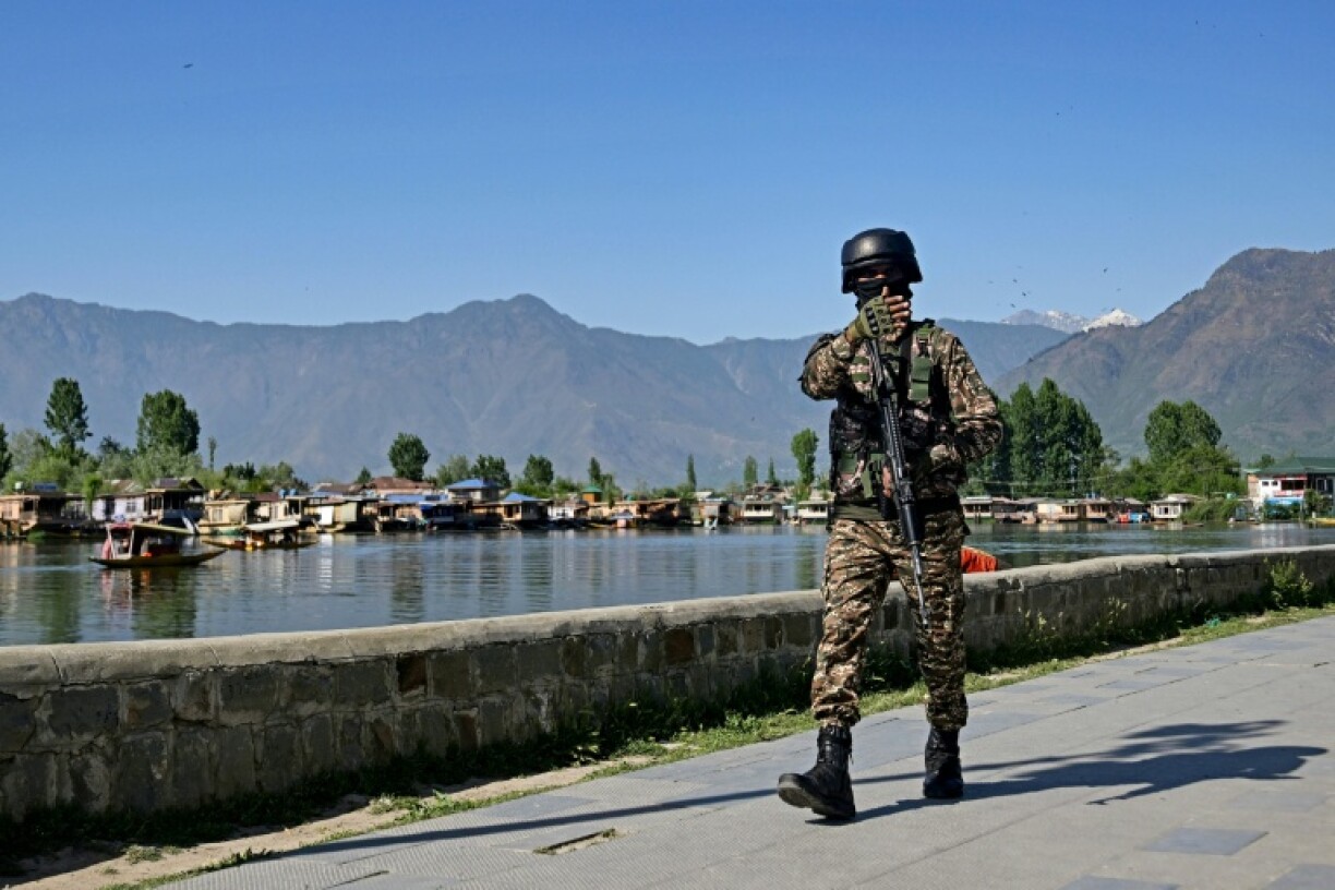 An Indian paramilitary officer patrols along the banks of Dal Lake in Srinagar
