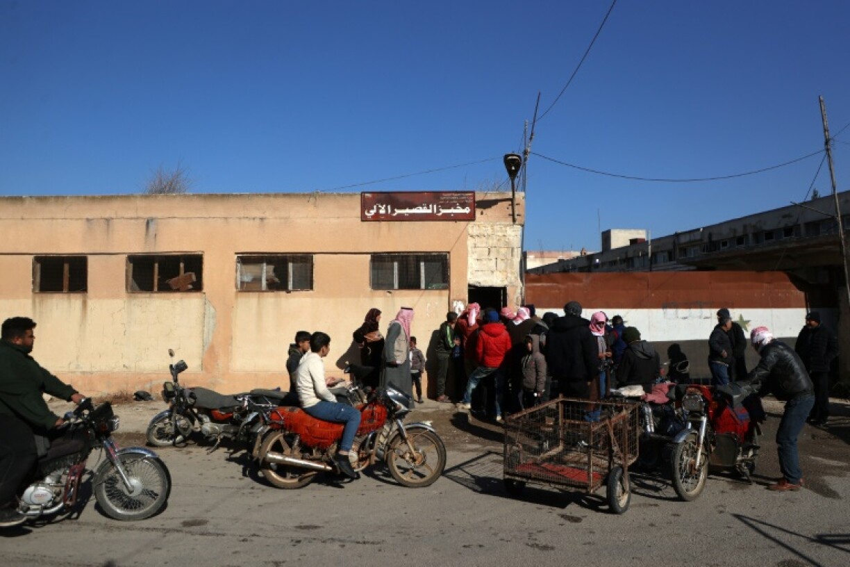 A queue to buy bread from a bakery in the town of Qusayr, in Homs province -- Syrians face a struggle for necessities