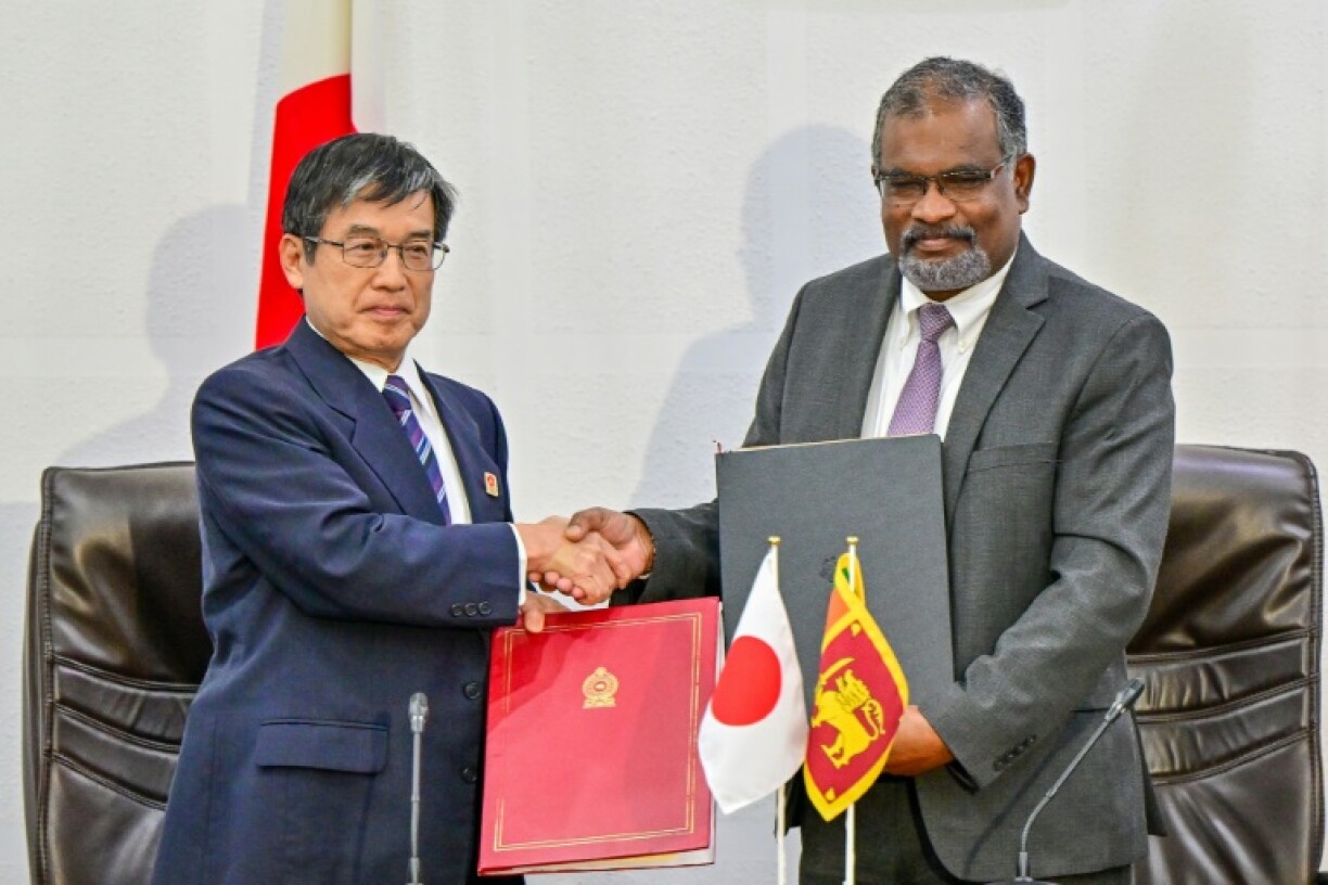 Japan's ambassador to Sri Lanka Akio Isomata (left) with Sri Lanka finance ministry secretary Mahinda Siriwardana after signing the debt restructuring agreement