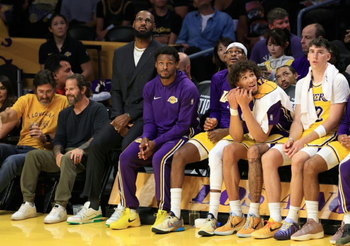 Injured LeBron James looks on from the bench during the Los Angeles Lakers' NBA season-opening loss to the Golden State Warriors