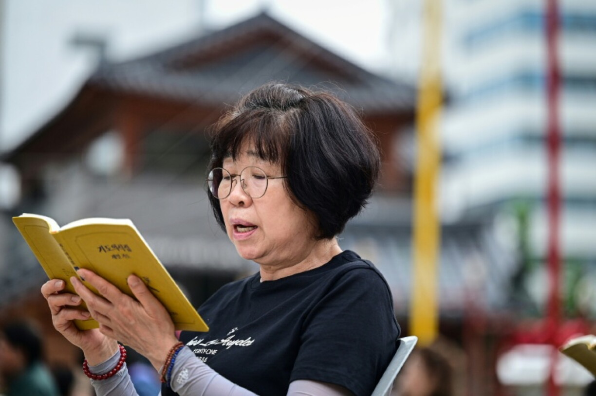 Cette photo prise le 2 juillet 2026 montre une femme priant au temple Jogyesa, à Séoul.