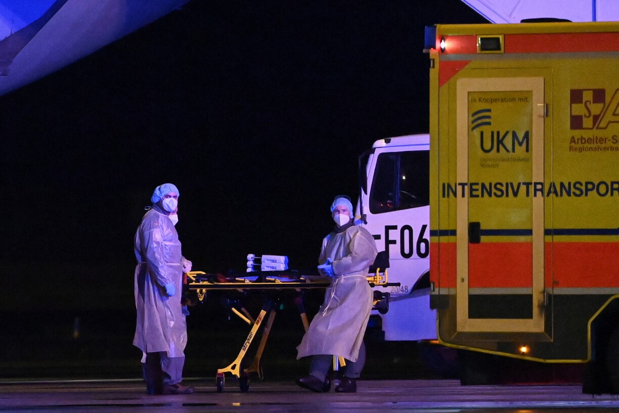 Medics wearing PPE are seen waiting to transport a patient infected with the coronavirus (Covid-19) to other intensive care units (ICU) from a MedEvac of the German armed forces Bundeswehr to an ambulance to move to other intensive care units (ICU) in the country, at Muenster Osnabruck Airport, northern Germany on November 26, 2021.