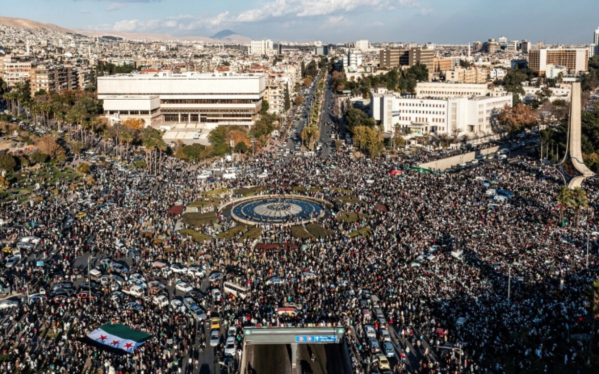 An aerial view of thousands celebrating the ouster of Syria's president Bashar al-Assad near the landmark Damascus Sword sculpture at Umayyad Square in central Damascus