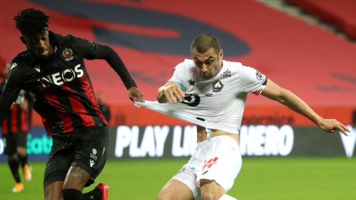 L'attaquant turc de Lille Burak Yilmaz (d) accroché par le défenseur brésilien de Nice Robson Bambu, le 25 octobre 2020 à Nice