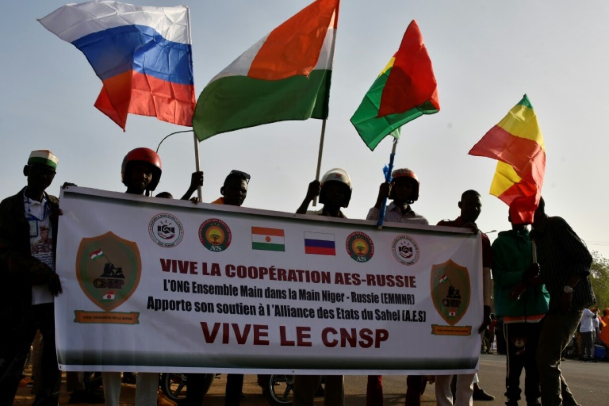 People waved flags from Russia, Niger, Burkina Faso and Mali at a rally to fete the withdrawal of the three Sahelian nations from the Economic Community of West African States