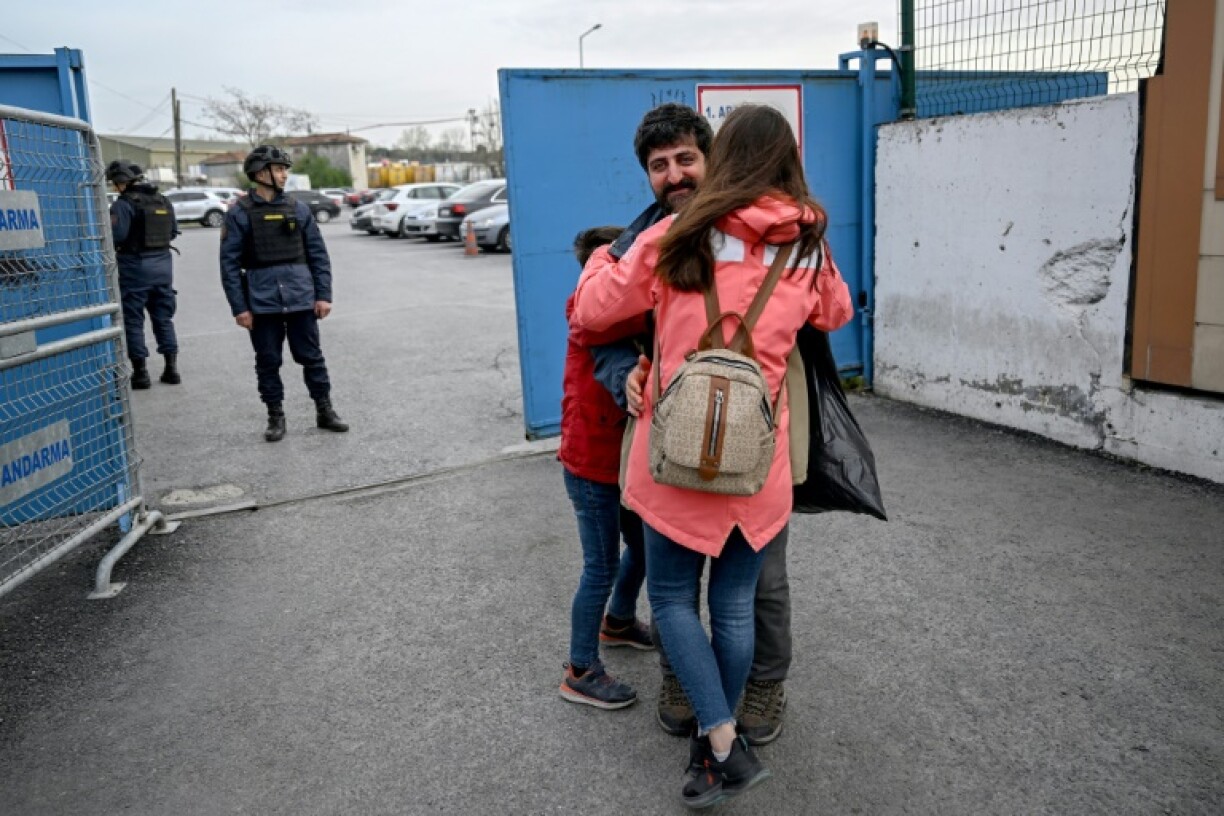 AFP photographer Yasin Akgul hugs his wife and son after being released from jail in Turkey