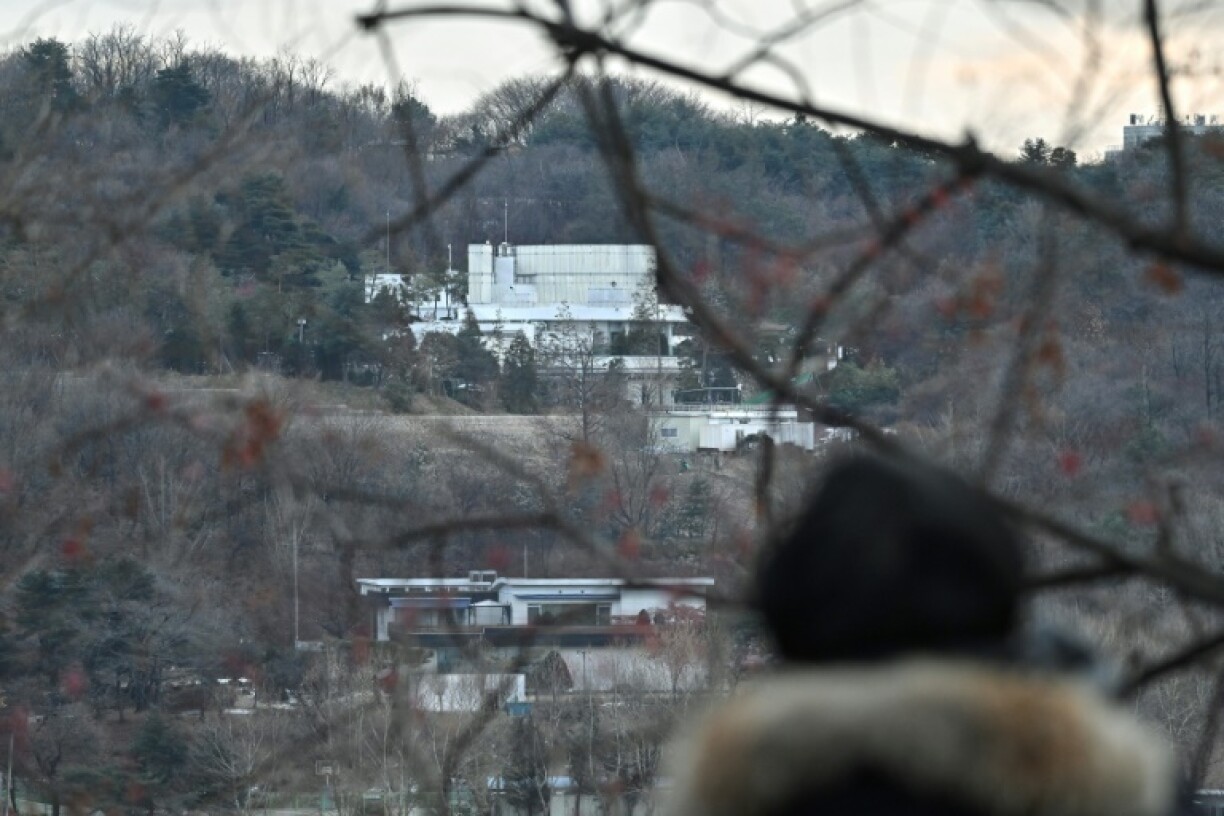 A man watches the presidential residence of impeached South Korean president Yoon Suk Yeol from a hill in Seoul