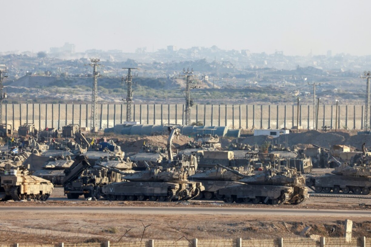 Une photo prise depuis la frontière israélienne avec la bande de Gaza montre des véhicules blindés militaires israéliens stationnés face aux bâtiments détruits dans le territoire palestinien, le 16 septembre 2025