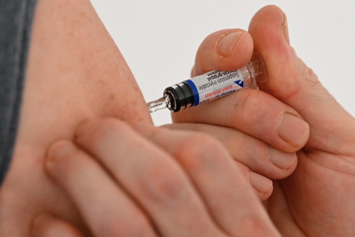 A health worker inoculates a man with a dose of the flu vaccine in January 2025