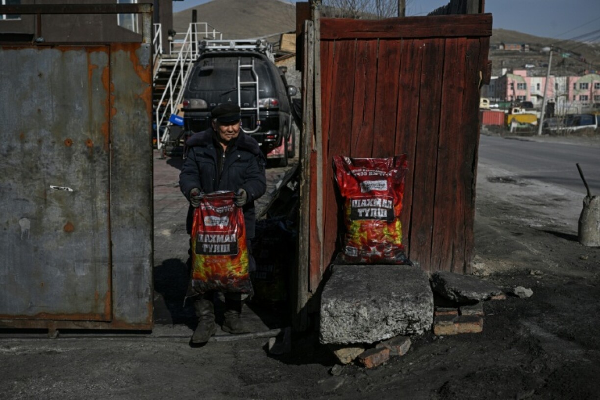 Coal seller Bayarkhuu Bold delivers bags of briquettes to customers to heat their homes