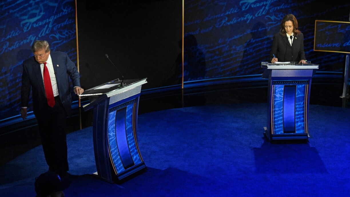 Former US President and Republican presidential candidate Donald Trump walks away during a commercial break as US Vice President and Democratic presidential candidate Kamala Harris take notes during their debate at the National Constitution Center in Philadelphia, Pennsylvania, on 10 September.