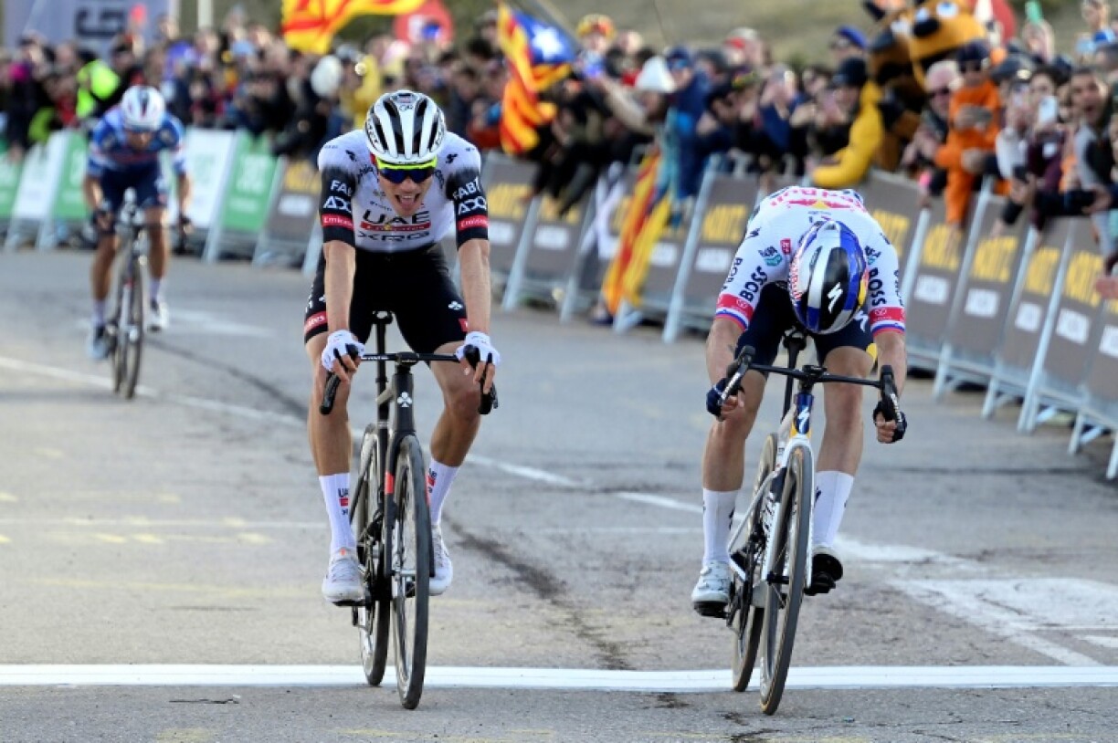 Juan Ayuso (C) and Primoz Roglic (R) cross the finish line in first and second place respectively at the end of stage three