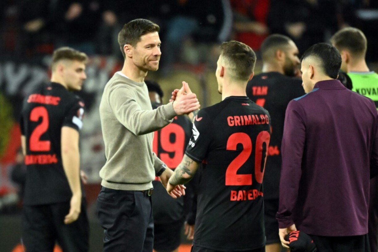 L'entraïneur du Bayer Leverkusen Xabi Alonso (à gauche) félicite ses joueurs à l'issue du match contre les anglais de West Ham à Leverkusen en Allemagne le 11 avril 2024