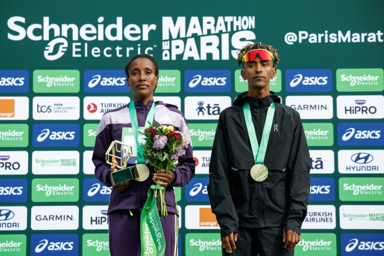 L'Ethiopienne Shure Demise (g) et l'Italien Yemaneberhan Crippa sur le podium du marathon de Paris qu'ils ont remporté le 12 avril 2026