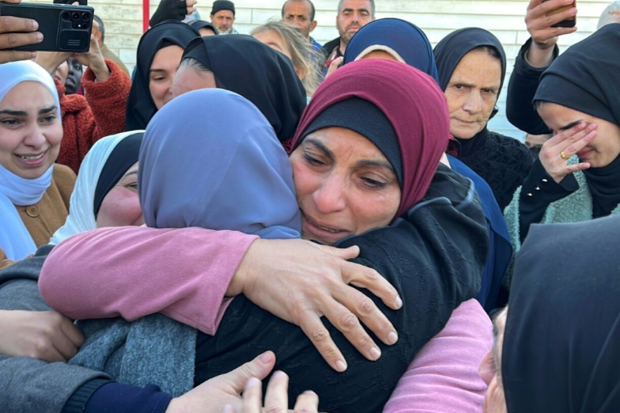 A freed Palestinian prisoner is embraced by family at the European Hospital in Khan Yunis in the southern Gaza Strip
