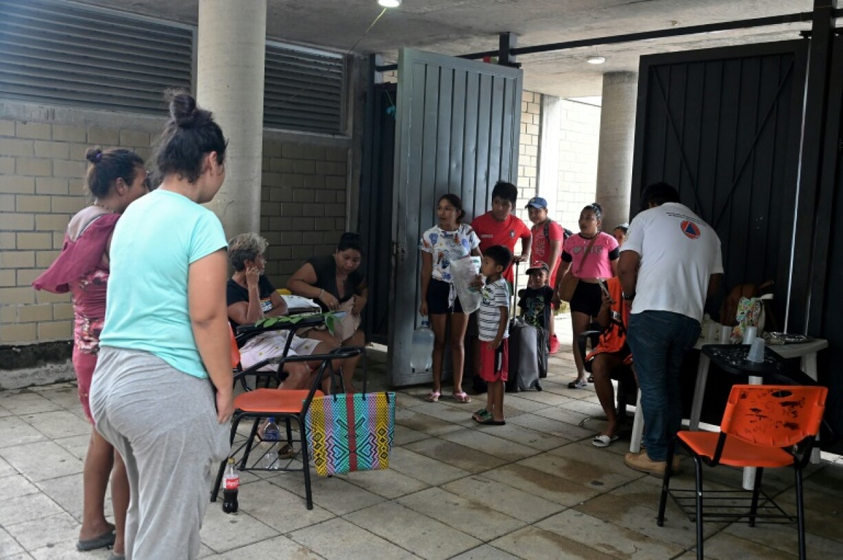 Des habitants arrivent dans un centre d'accueil installé dans une école avant l'arrivée de l'ouragan Erick, le 18 juin 2025 à Acapulco, dans le sud du Mexique