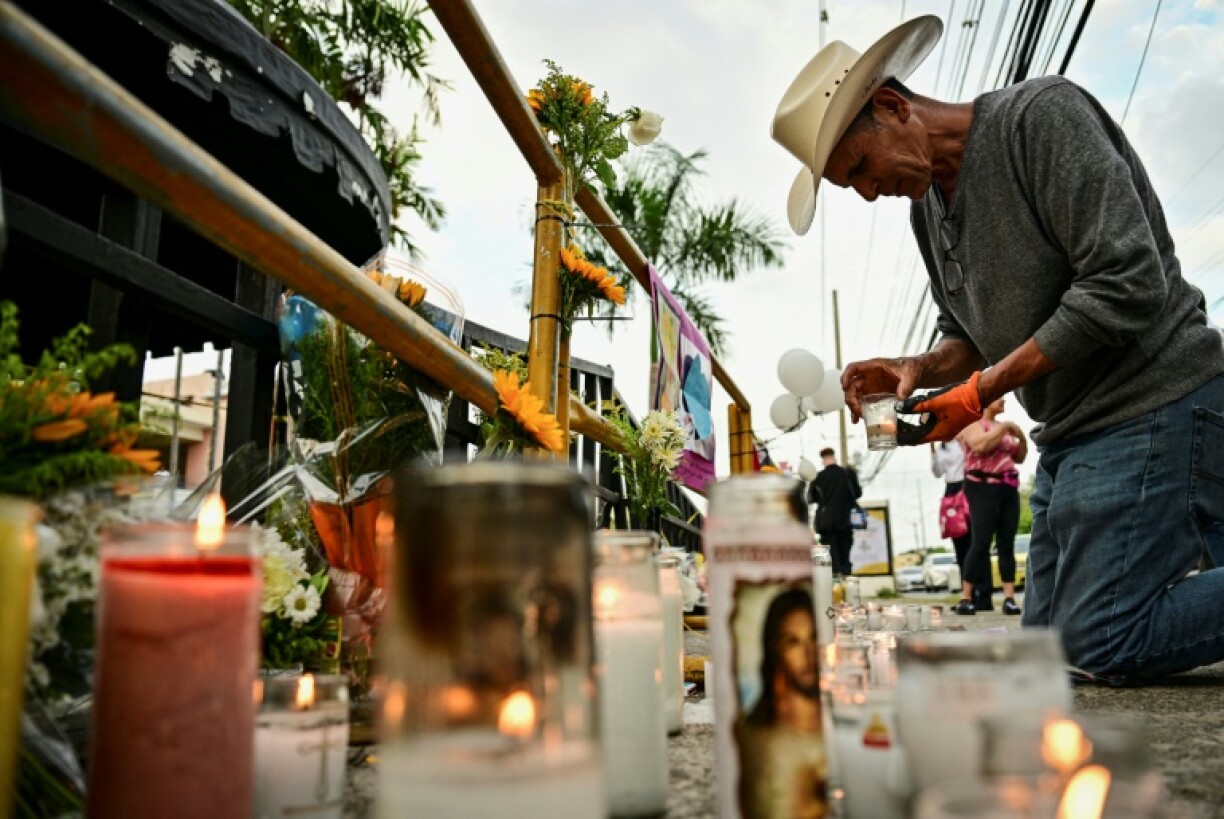 A man lights a candle in tribute to victims of the Jet Set nightclub roof collapse in Santo Domingo