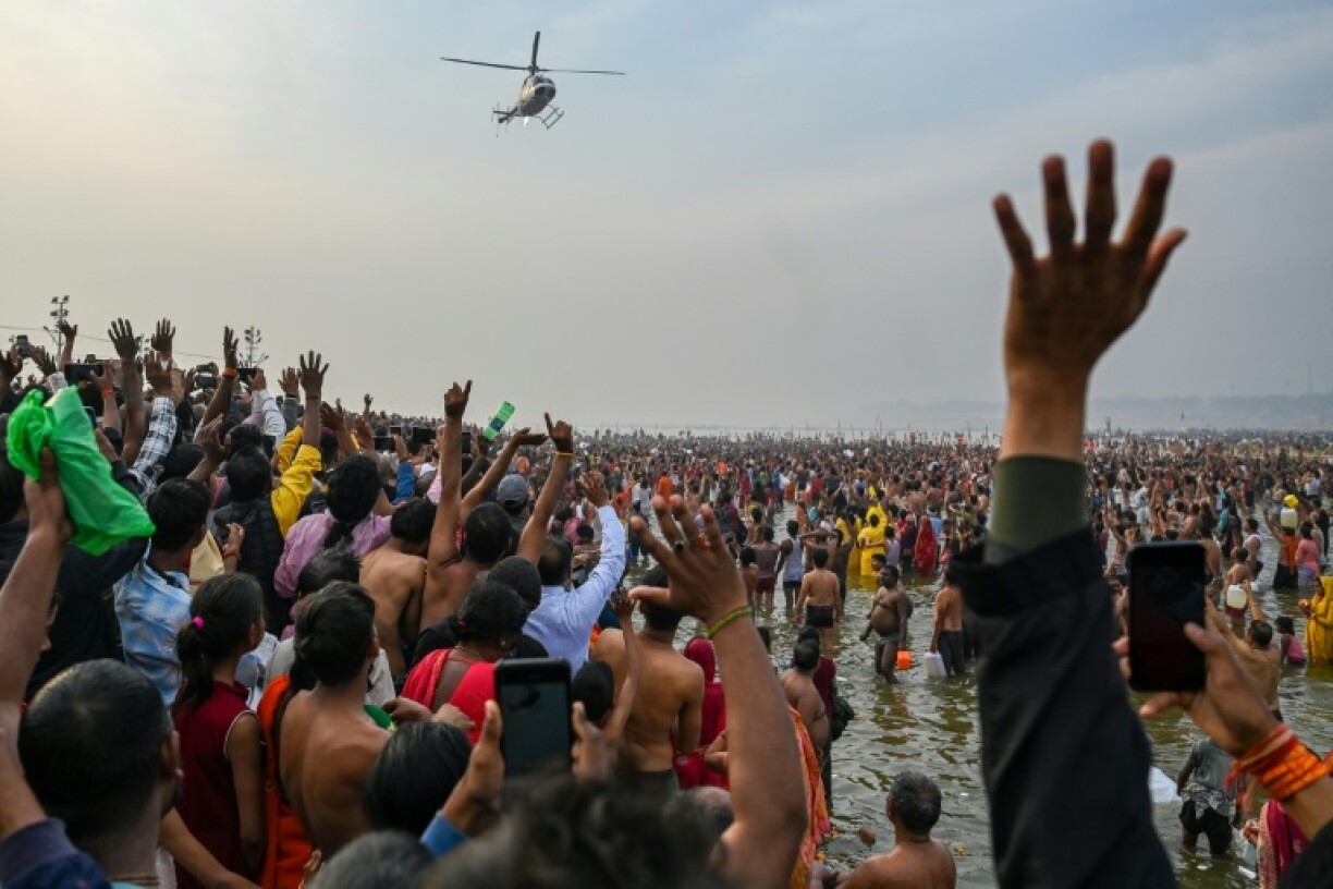 A helicopter showers flower petals on pilgrims on the final day of India's Kumbh Mela