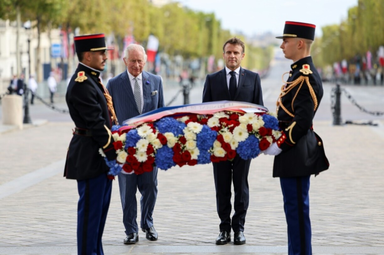 Le roi Charles III (2e à g) dépose une gerbe aux côtés du président français Emmanuel Macron (2e à d) sur la tombe du Soldat inconnu sous l'Arc de Triomphe à Paris, le 20 septembre 2023