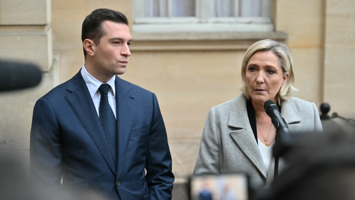 Jordan Bardella (L) and Marine Le Pen speaking to the media following a Paris meeting on 16 December 2024.
