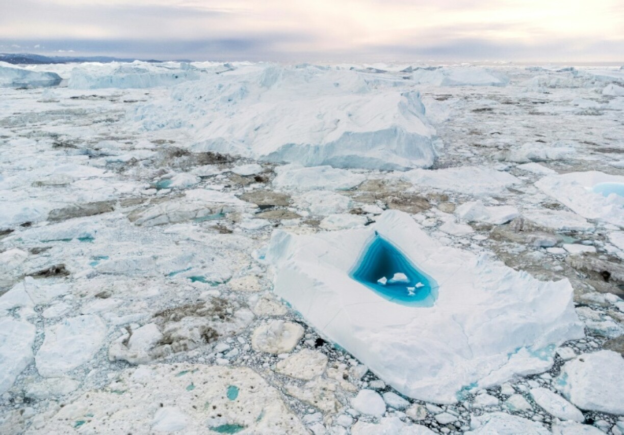 Turquoise water in a large melt hole on an iceberg in Disko Bay, western Greenland, in a picture from June 29, 2022