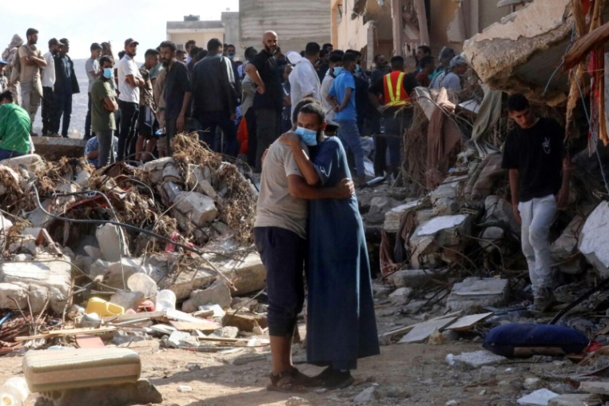 Residents search mangled buildings for missing loved ones and bulldozers clear streets of debris and mountains of sand