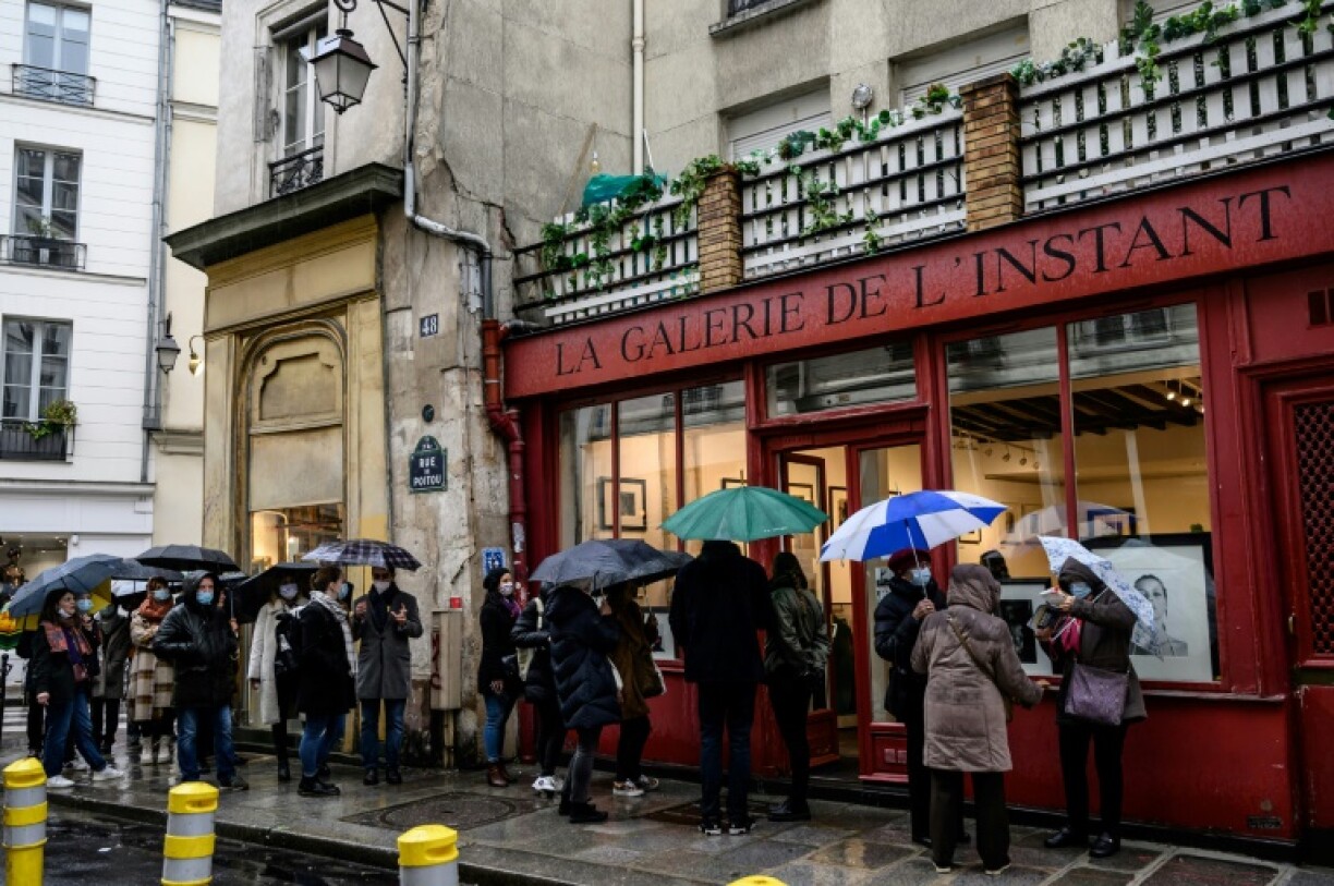 Des visiteurs font la queue devant la Galerie de l'instant à Paris, le 6 février 2021