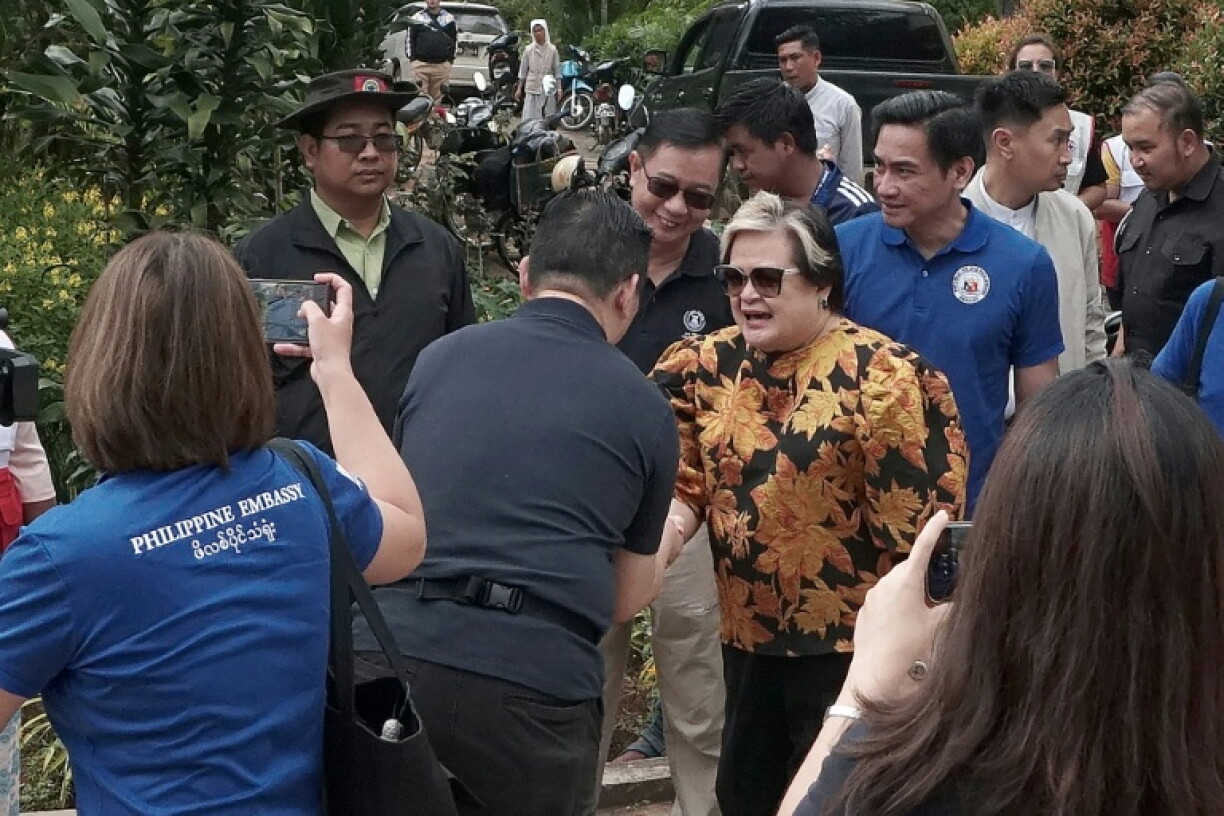 Association of Southeast Asian Nations (ASEAN) special envoy and Philippines' Foreign Minister Secretary Maria Theresa Lazaro (C) shakes hands with a man during an ASEAN humanitarian monitoring mission to support affected and displaced communities in Taunggyi, southern Shan State on October 28, 2026.