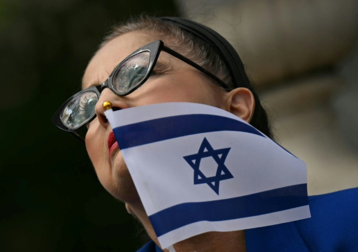 A woman holds an Israeli flag in a sign of support outside the Capital Jewish Museum following a shooting that left two people dead