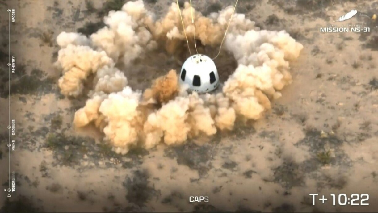 The capsule lands in a cloud of dust