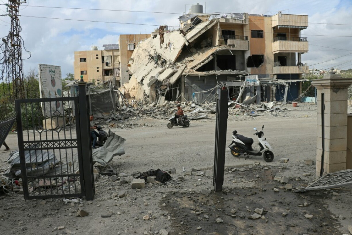 Un homme passe en moto devant un bâtiment abritant une ONG, détruit par une frappe israélienne, dans la ville de Tyr, dans le sud du Liban, le 15 mai 2026