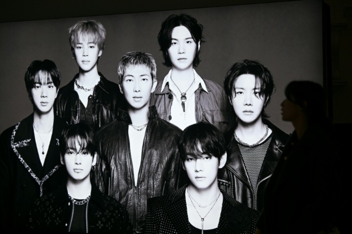 Un visiteur passe devant une photo du groupe de K-pop BTS dans un grand magasin de Séoul, le 20 mars 2026