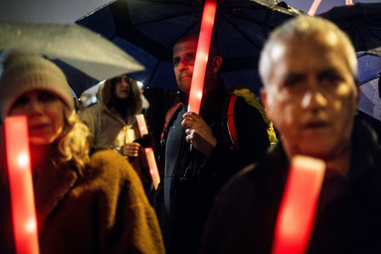 Protesters hold up red lights during a demonstration in Jerusalem on March 20, 2025 against Israel's Prime Minister Benjamin Netanyahu’s decision to oust the head of Shin Bet