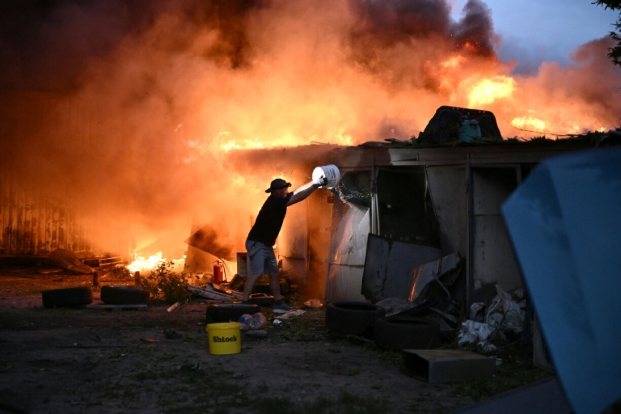 Un habitant tente d'éteindre un incendie provoqué par un missile russe à Kiev, le 6 juillet 2026