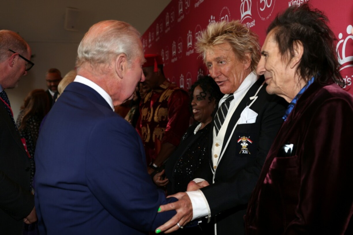 Le chanteur britannique Rod Stewart (c) salue le roi Charles III (g), aux côtés du guitariste britannique Ronnie Wood, à Londres, le 11 mai 2026
