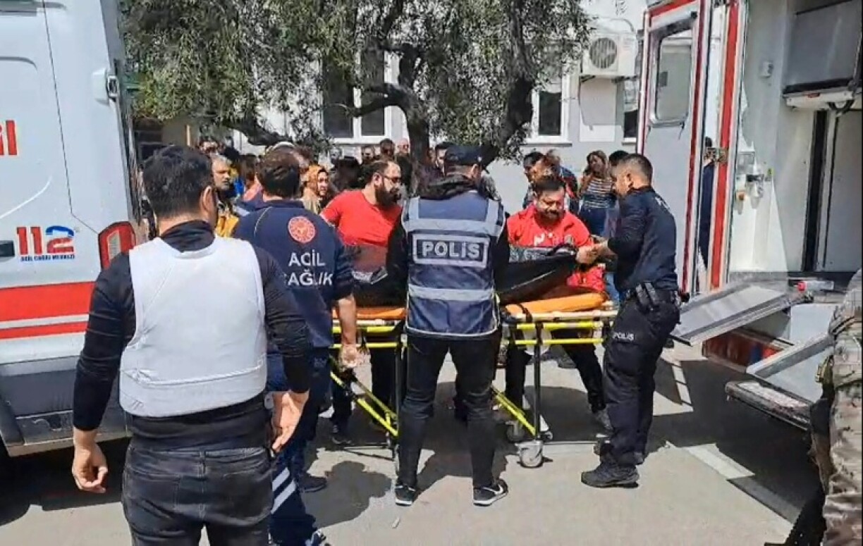 Photo diffusée le 15 avril 2026 par l'agence de presse turque DHA (Demiroren News Agency) montrant des secouristes transportant un sac mortuaire à Kahramanmaraş, dans le sud de la Turquie, après des tirs dans une école