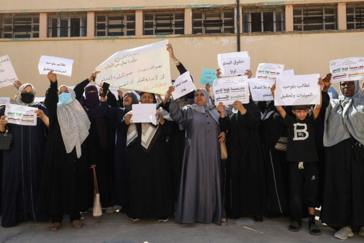 Teachers hold up placards during a demonstration demanding higher salaries and better working conditions at a school in Tripoli on September 29, 2026.