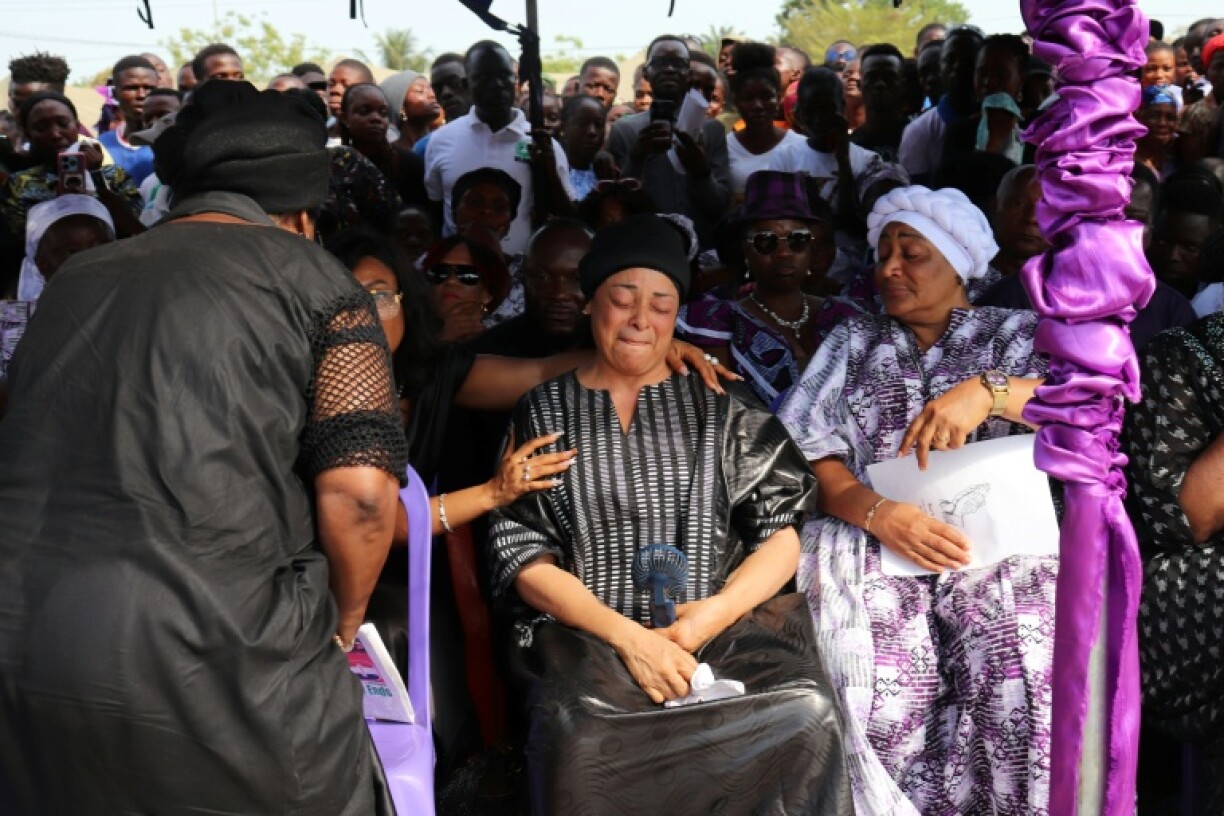 Prince Johnson's widow (C) was among those attending the funeral