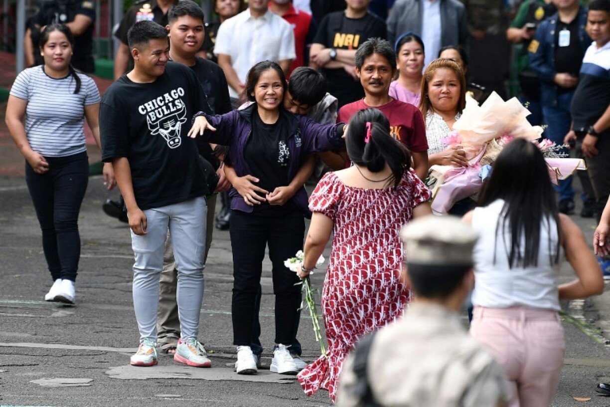 Mary Jane Veloso (C) greets relatives as she stands next to her two sons after arriving at a Manila prison on Wednesday