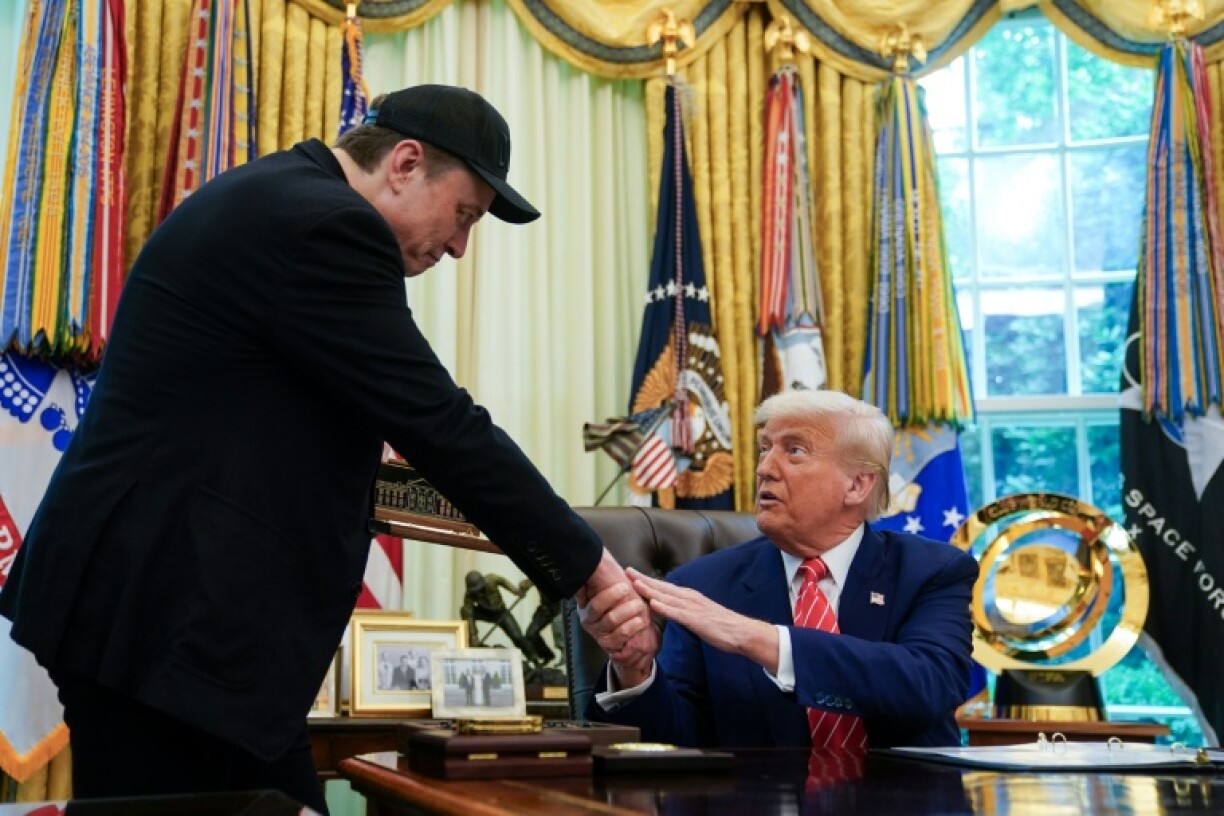 US President Donald Trump shakes hands with Elon Musk