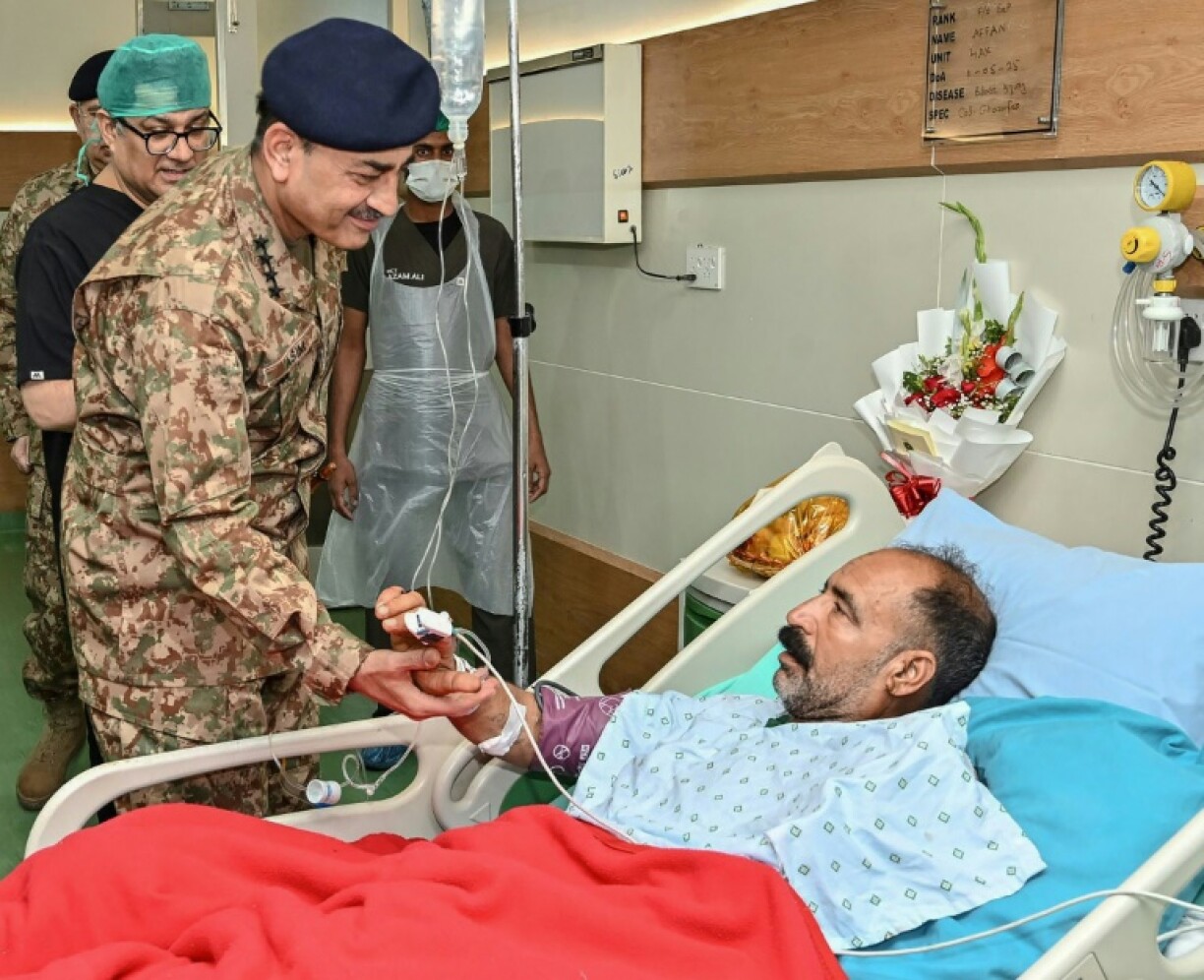 A handout photograph released by the Pakistan military's media wing shows Chief of Army Staff General Syed Asim Munir greeting an injured civilian at a hospital in Rawalpindi