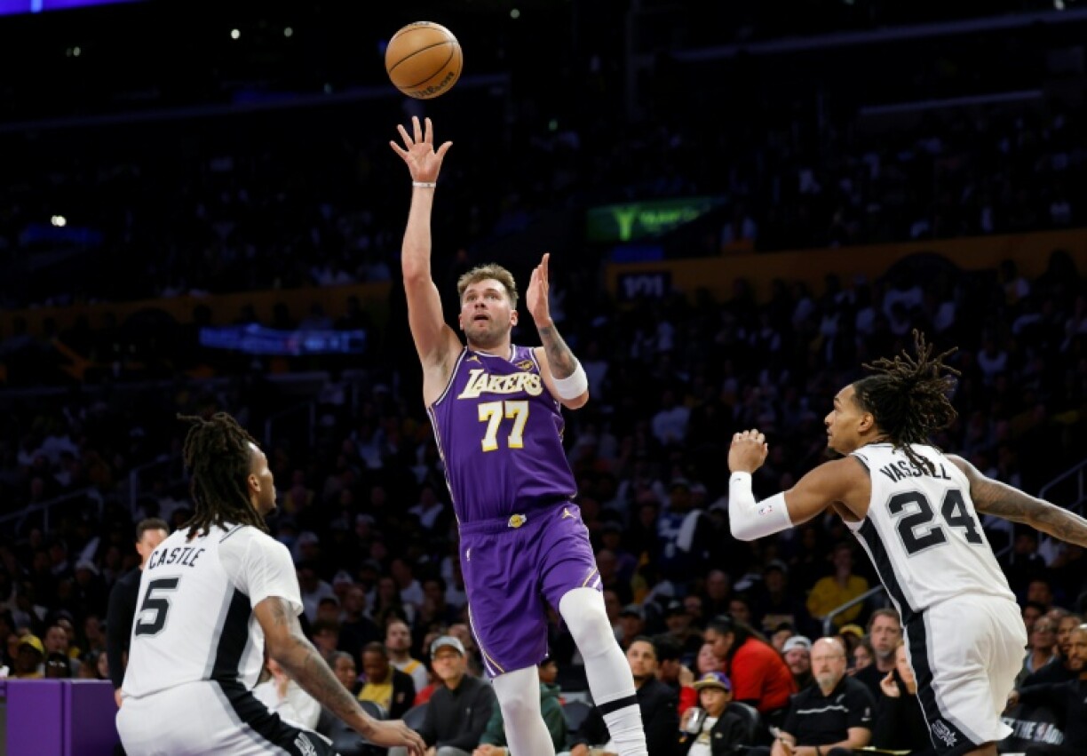 Luka Doncic of the Los Angeles Lakers passes between Stephon Castle and Devin Vassell in the Lakers' NBA victory over the San Antonio Spurs