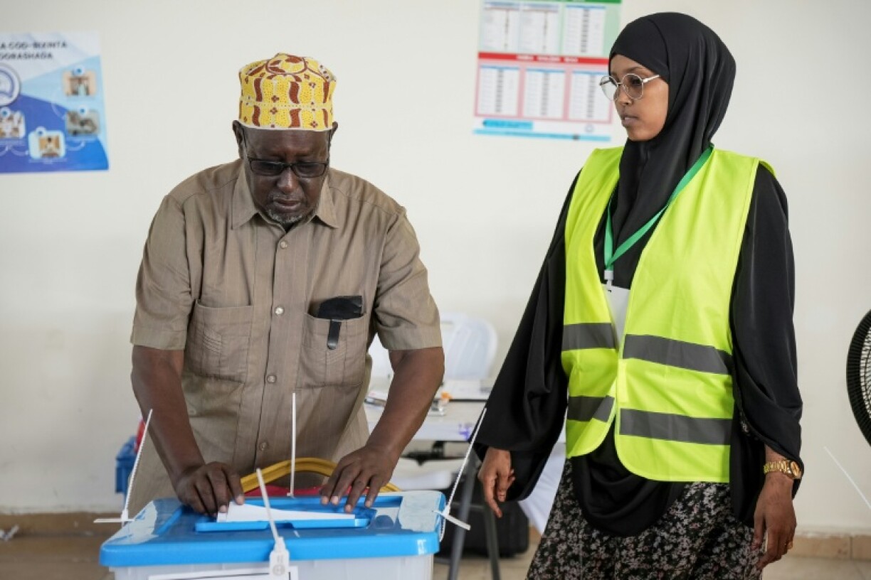 Un électeur glisse son bulletin de vote pour les élections locales de Mogadiscio, en Somalie, le 25 décembre 2025