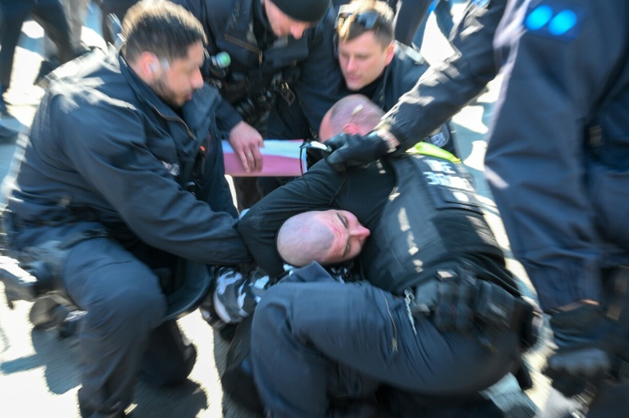 Police detain a protester during a demonstration by far-right supporters in Berlin on March 22, 2025
