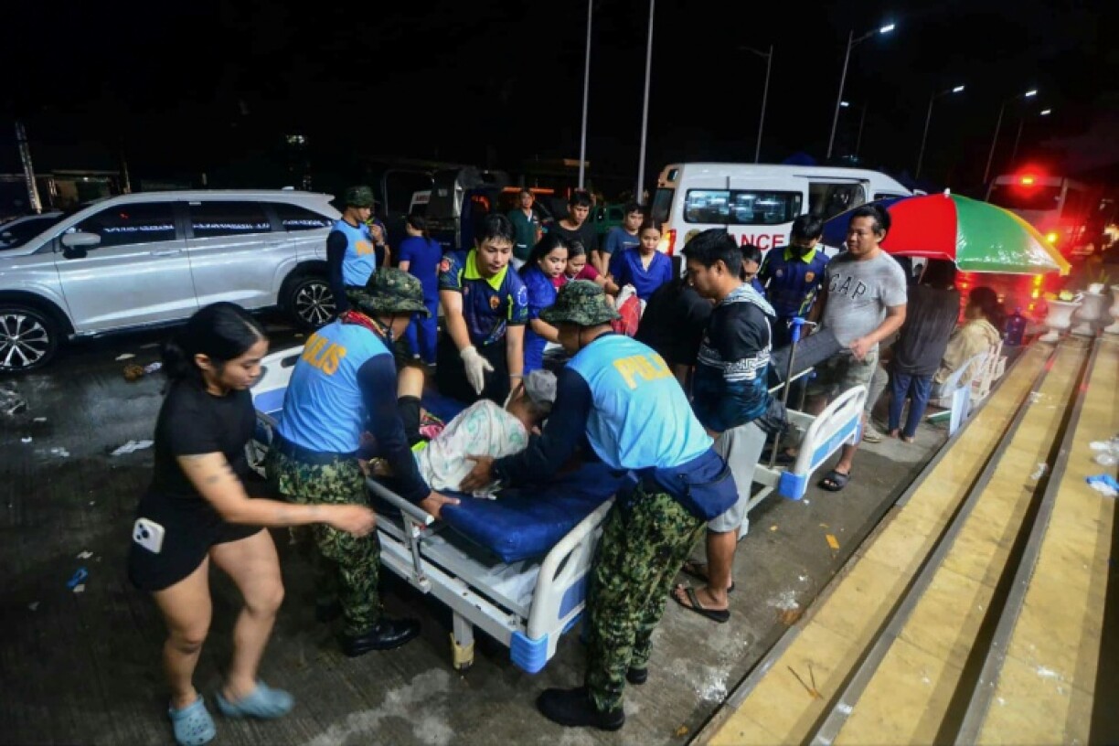 Police assist injured residents as they are brought to the hospital in Bogo City, Cebu province, central Philippines