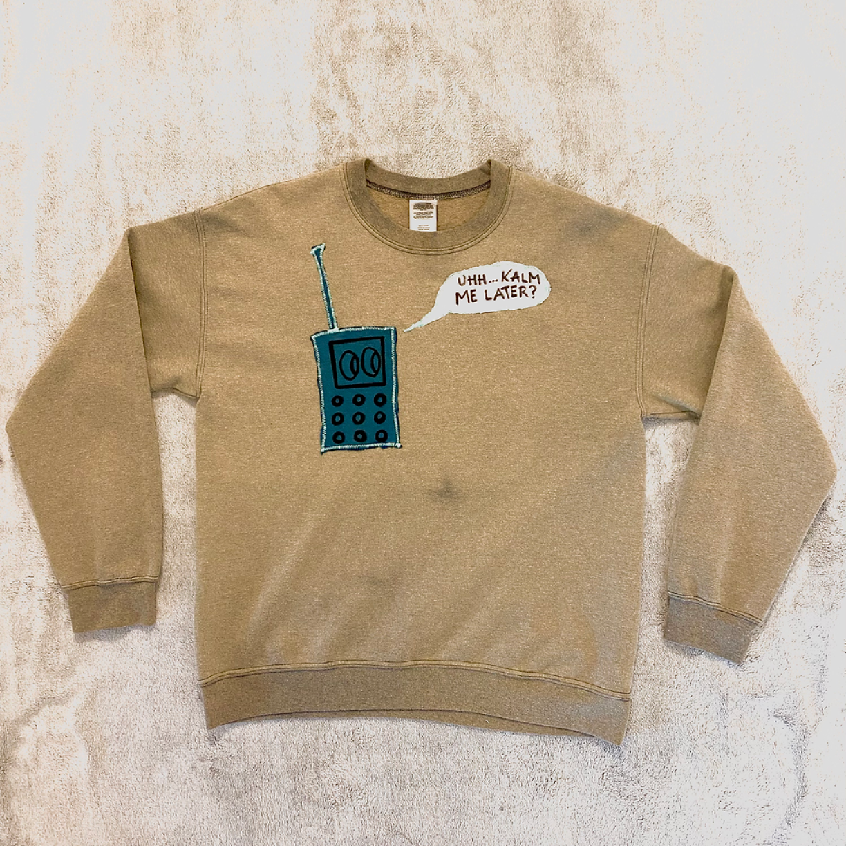 Un pull seconde-main avec des motifs brodés provenant de tissu récupéré.