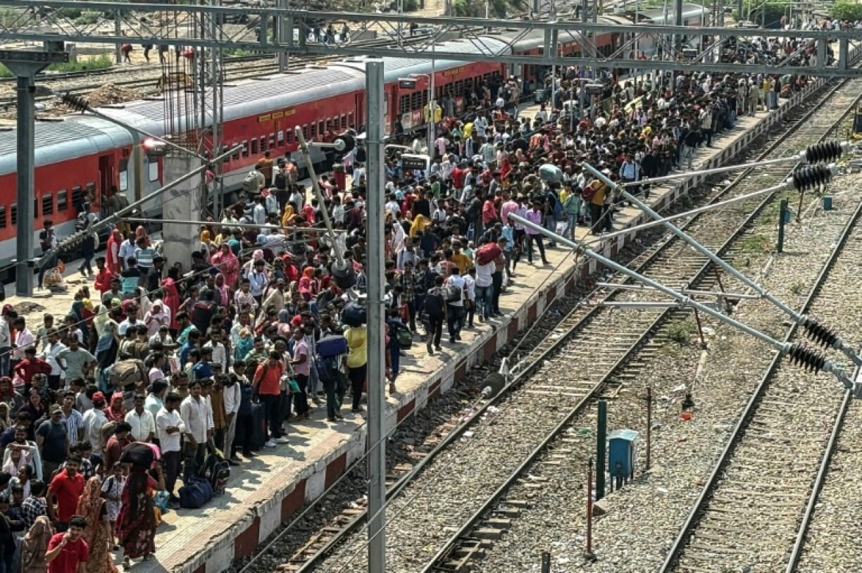 Migrants wait to board a train to leave Jammu in Indian-administered Kashmir