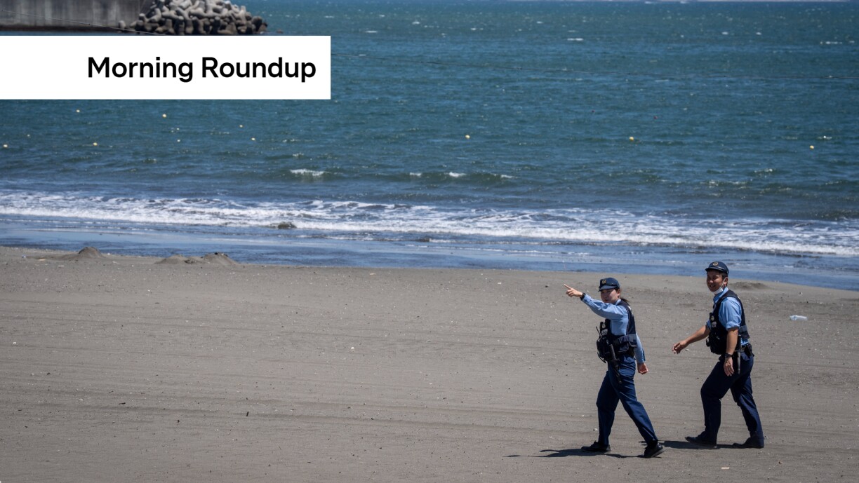 Police officers ask people to evacuate a beach due to a tsunami warning in Fujisawa city, Kanagawa prefecture, on 30 July 2025.