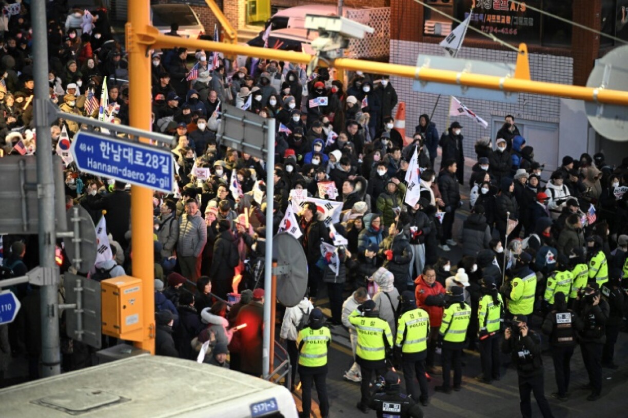 Policemen stand guard in front of people taking part in a rally to support South Korea's impeached president Yoon Suk Yeol