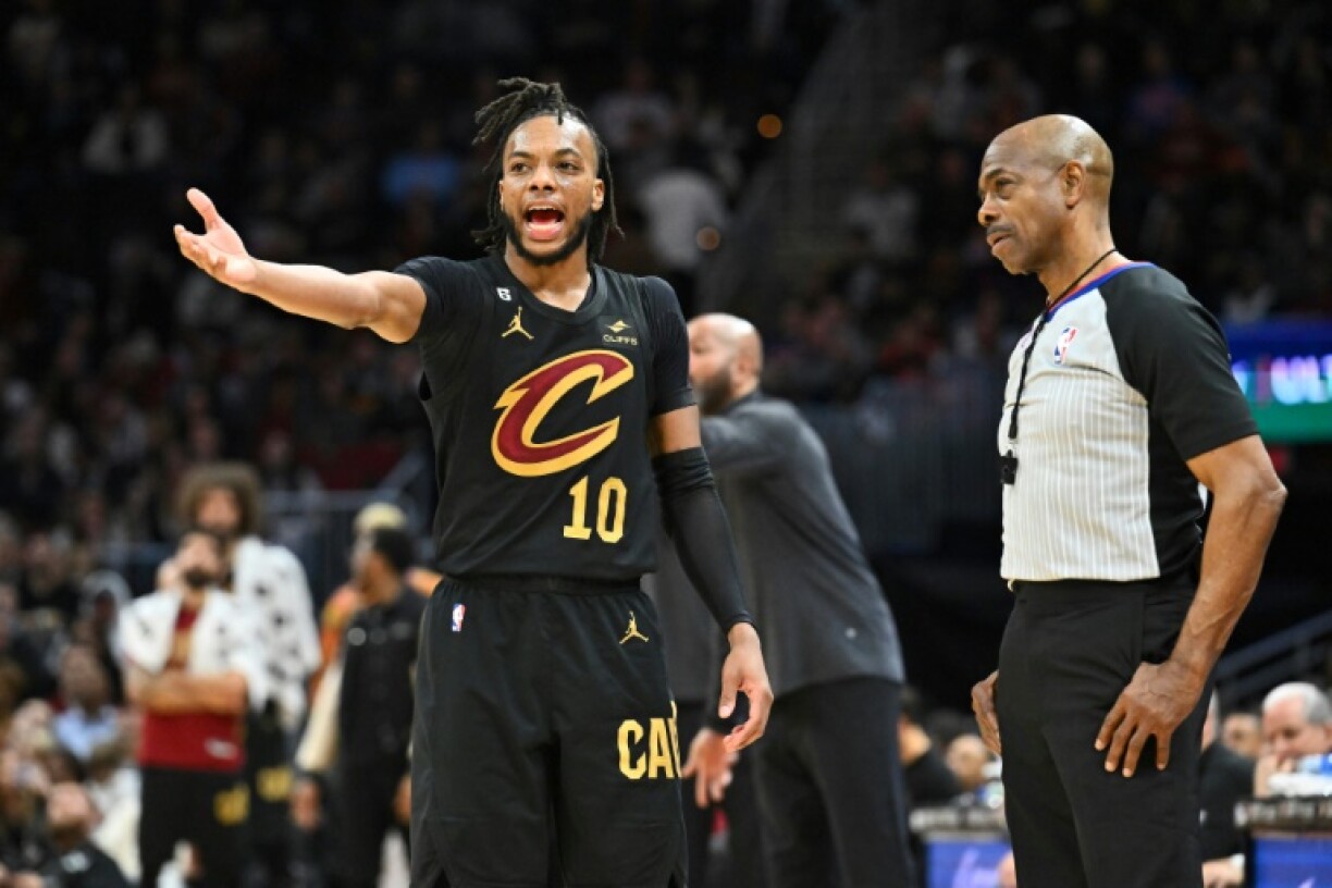 Darius Garland (g.), des Cleveland Cavaliers, discute avec l'arbitre Tom Washington (d.) pendant le quatrième quart-temps du matvh NBA contre les Milwaukee Bucks, à Cleveland, le 21 janvier 2023